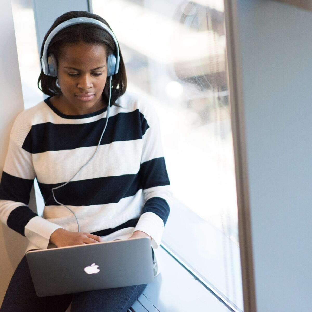 Girl listening to headphones on laptop